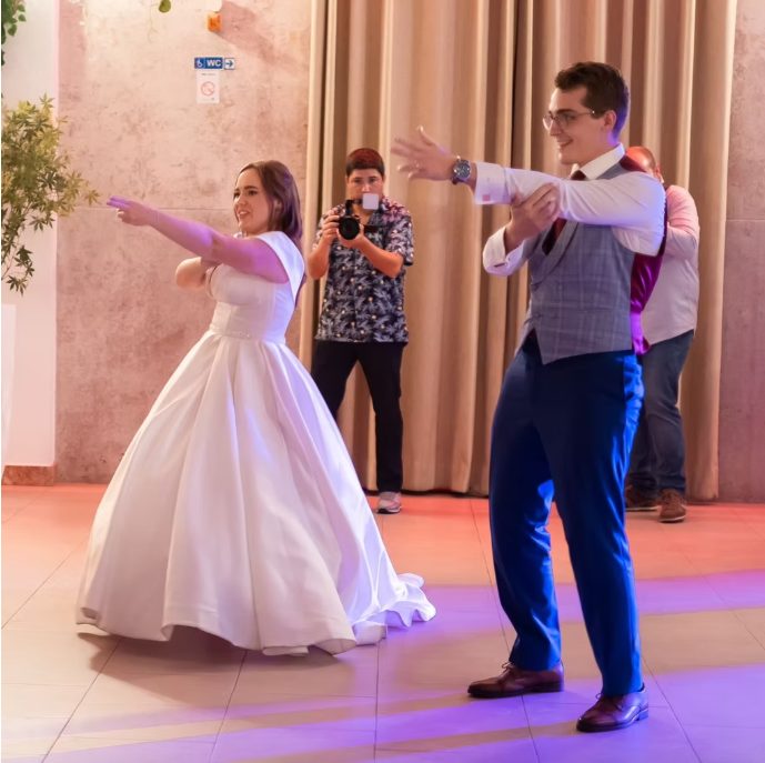 Noivos a apontar e a rir durante um momento de dança
