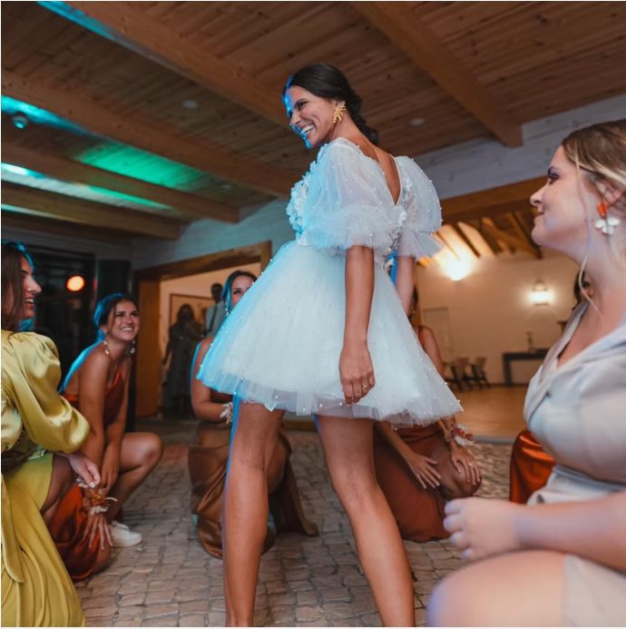 Damas de honor a rir em redor da noiva a dançar