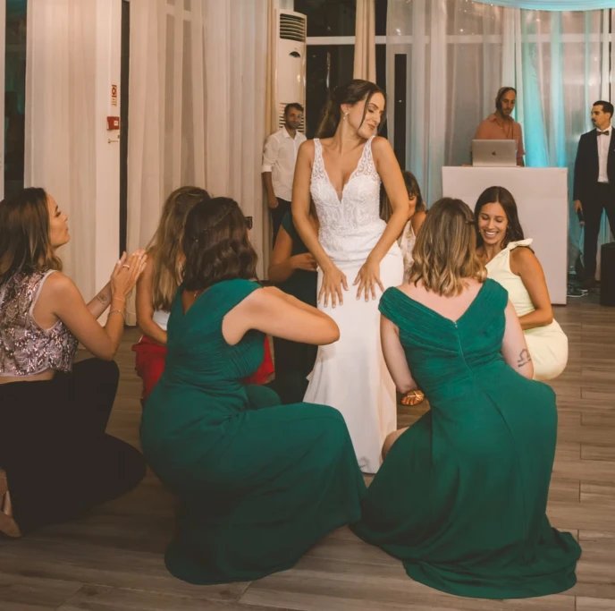 Noiva e damas a dançar de joelhos numa despedida de solteira